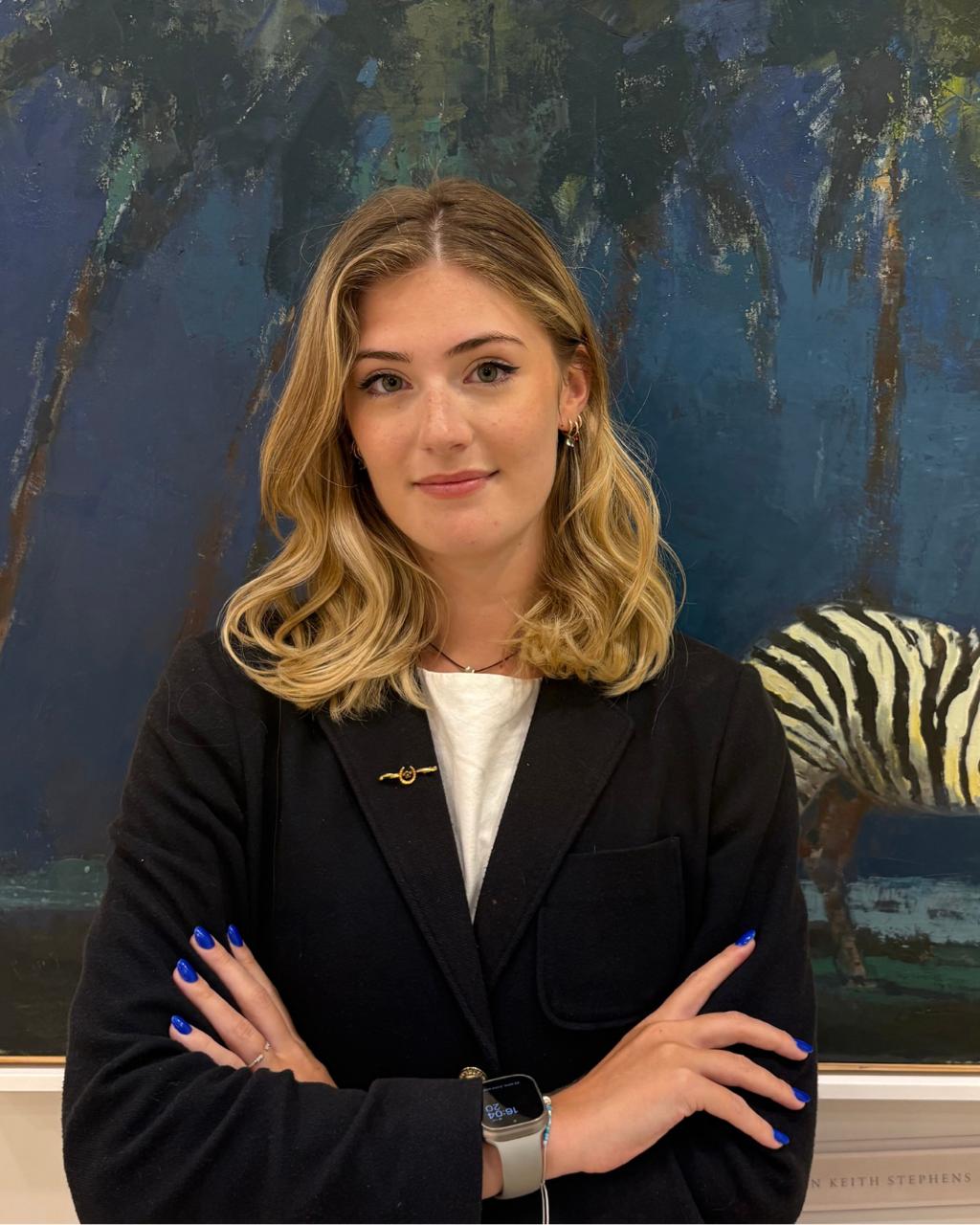 Megan Scarborough, founder of Art Pulse London, in front of a large blue painting